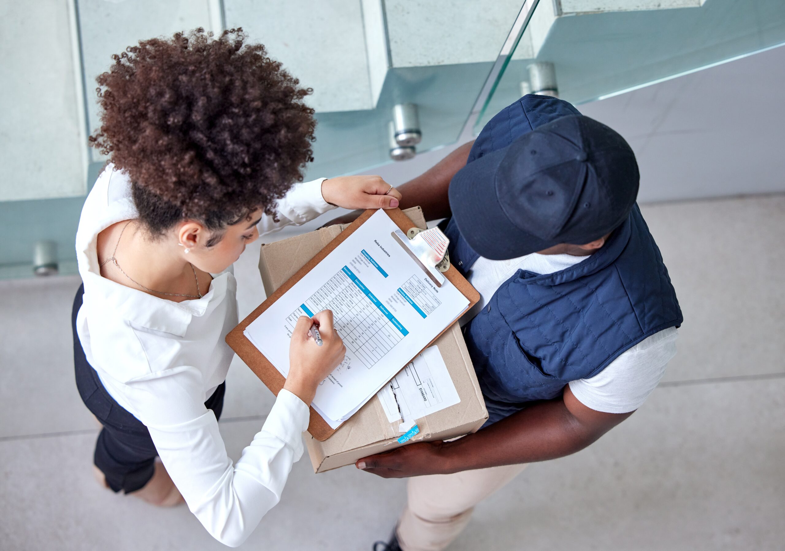 woman in office signing for courier delivery of package 